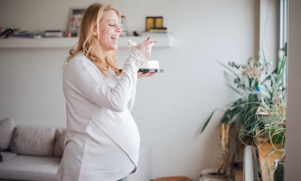 Femme enceinte qui s'apprête à manger une cuillière de son dessert de Noël